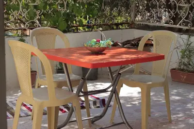 a red table with chairs and a bowl of fruit on it at بيت الطبيعة nature house in Jerash