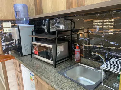 a kitchen counter with a microwave and a sink at Tayoon Host in Jerash