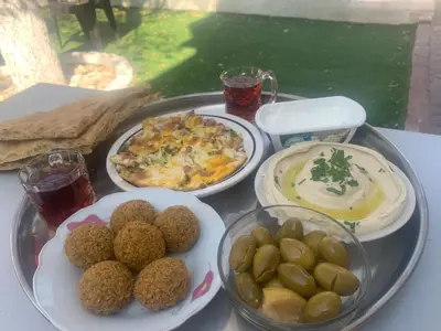 a tray of food on a table with plates of food at Tayoon Host in Jerash