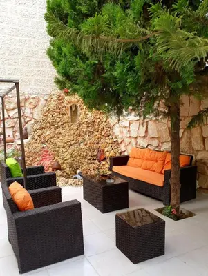 an outdoor seating area with chairs and a tree at Tell Madaba in Madaba