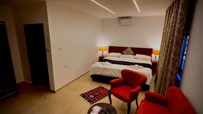 a bedroom with a bed and a red chair at Tell Madaba in Madaba