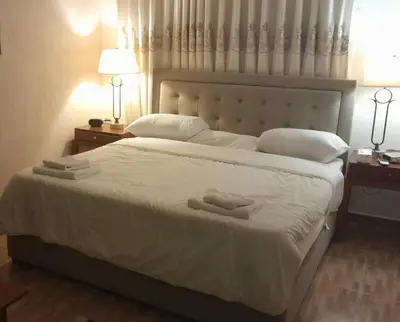 a bedroom with a large white bed with two towels on it at Tell Madaba in Madaba
