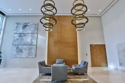 a room with two chairs and a table and a chandelier at Abdali Views Apartments in Amman