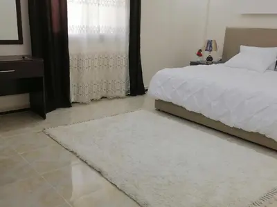 a bedroom with a white bed and a rug at Petra Guests home in Wadi Musa