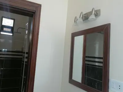 a bathroom mirror with a wooden frame and lights on the wall at Petra Guests home in Wadi Musa