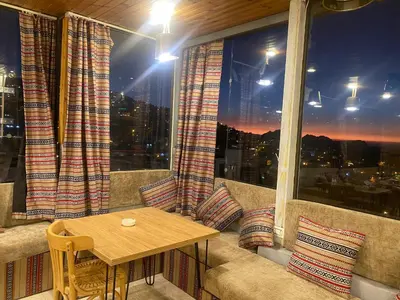 a balcony with a table in front of a window at Raqeem Hotel in Wadi Musa