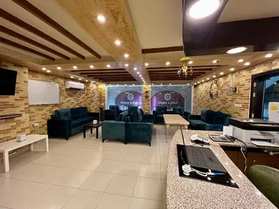a lobby with couches and a table with a laptop at Raqeem Hotel in Wadi Musa