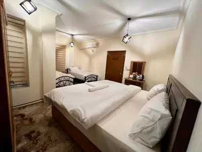 a bedroom with a large bed with white sheets at Raqeem Hotel in Wadi Musa