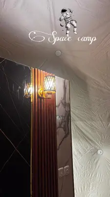 a room with a mirror and a sign on the ceiling at Wadi Rum Space camp in Wadi Rum