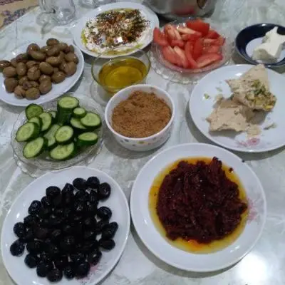 a table with plates of food on a table at Fog Mountain Hotel Rooms & sauna in Jaḩrāʼ