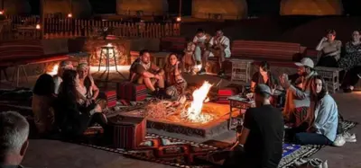 a group of people sitting around a fire in a room at JULIA RUM lUXURY CAMP in Wadi Rum
