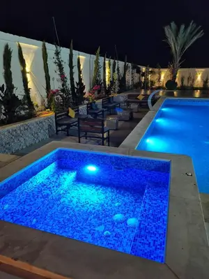 a swimming pool at night with blue lights at The Legend Villa فيلا الاسطوره in Sowayma