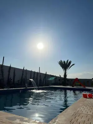 a swimming pool with a fountain in the middle at The Legend Villa فيلا الاسطوره in Sowayma
