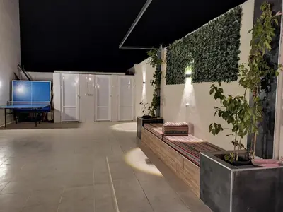 a room with plants on the wall and a tv at The Legend Villa فيلا الاسطوره in Sowayma