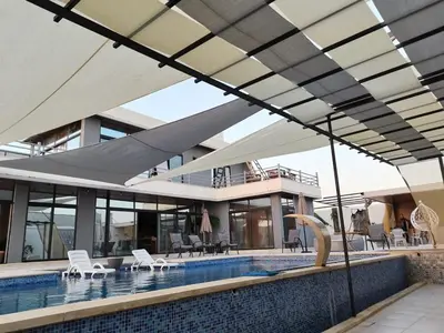 a house with a swimming pool with a roof at The Legend Villa فيلا الاسطوره in Sowayma