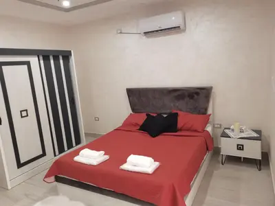 a bedroom with a red bed with towels on it at The Legend Villa فيلا الاسطوره in Sowayma