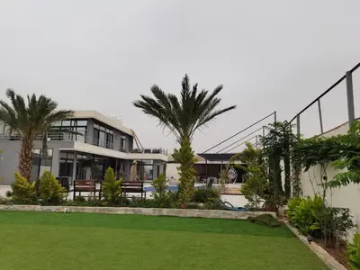 a large house with palm trees and a yard at The Legend Villa فيلا الاسطوره in Sowayma