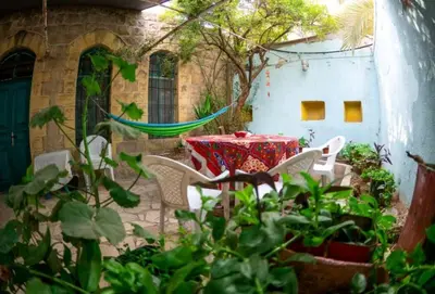 a patio with a table and chairs and plants at Shams House in Amman