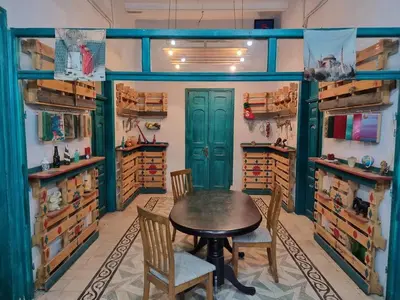 a dining room with a table and chairs and shelves at Shams House in Amman