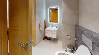 a bathroom with a sink and a toilet and a mirror at Al Fares Luxury furnished Apartment-Damac Tower in Amman
