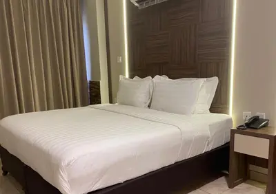 a bed with white sheets and pillows in a room at Mass Boutique hotel in Aqaba