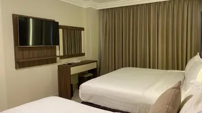 a hotel room with two beds and a flat screen tv at Mass Boutique hotel in Aqaba