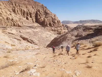 a group of people walking in the desert at Mad Mix camp in Wadi Rum
