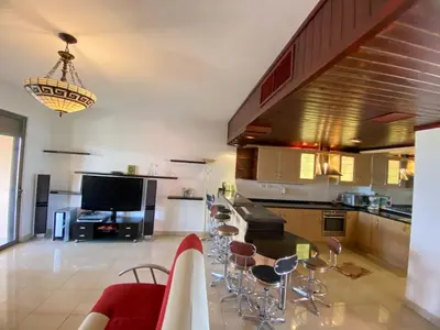 a kitchen with a table and some chairs in it at one bedroom apartments aqaba on for family only 2 swimming pool Tala bay for family only in Aqaba