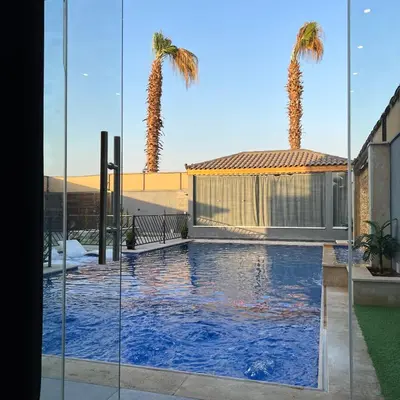 a swimming pool with palm trees on a building at Aroma Mountain Dead Sea in Sowayma