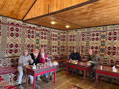a group of people sitting at tables in a restaurant at Desert Jewel Camp in Wadi Rum