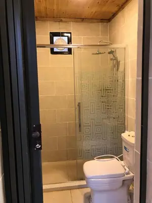 a bathroom with a toilet and a glass shower at Desert Jewel Camp in Wadi Rum
