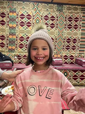 a young girl is smiling for the camera at Desert Jewel Camp in Wadi Rum