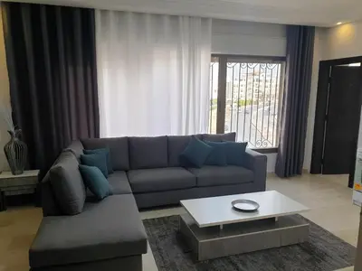 a living room with a couch and a coffee table at Deir Ghbar-Studio in Amman