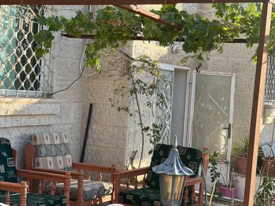 a patio with two chairs and a table and a window at Petra luxurious view house in Wadi Musa