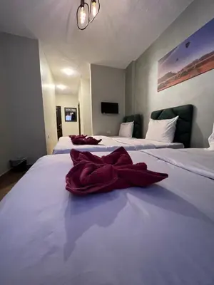 two beds with red towels sitting on top of them at Sandra Hotel in Amman