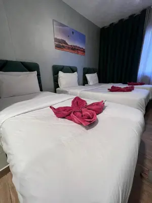 two beds in a room with red roses on them at Sandra Hotel in Amman