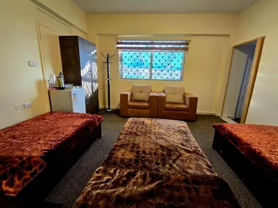a room with two beds and a couch and a window at Petraone in Wadi Musa