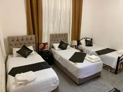 a room with three beds in a hotel room at Its your choice hostel in Wadi Musa