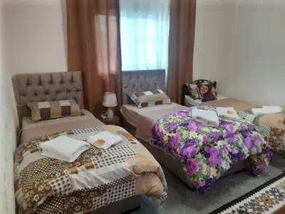 a bedroom with two beds and a woman on the bed at Its your choice hostel in Wadi Musa