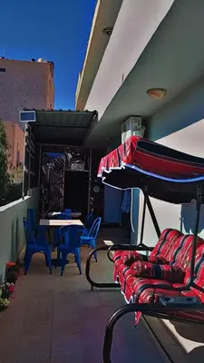 a patio with a table and chairs and an umbrella at Its your choice hostel in Wadi Musa