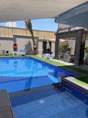 a large blue swimming pool next to a building at Villa Jana chalet - Private Villa - Dead Sea - Jordan in Ash Shāghūr