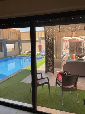 a view of a pool with a table and chairs at Villa Jana chalet - Private Villa - Dead Sea - Jordan in Ash Shāghūr