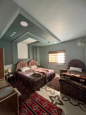 a bedroom with two beds and a large mirror at Beida Bedouin House in Al Ḩayy
