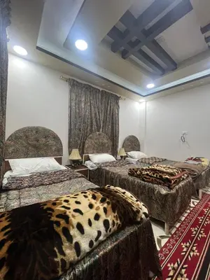 a room with two beds with animal print sheets at Beida Bedouin House in Al Ḩayy