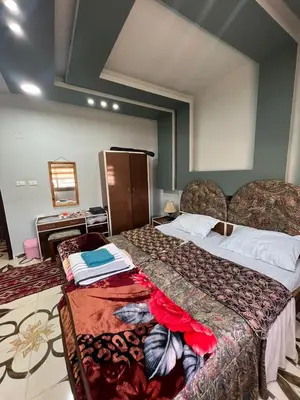 a hotel room with two beds and a table at Beida Bedouin House in Al Ḩayy