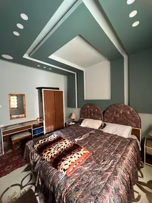 a bedroom with a large bed in a room at Beida Bedouin House in Al Ḩayy