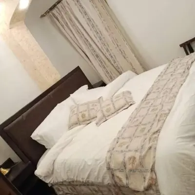a bed with white sheets and pillows in a bedroom at ZRIZIRA INN in Wadi Musa