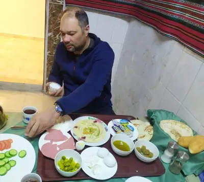 a man sitting at a table preparing food at ZRIZIRA INN in Wadi Musa