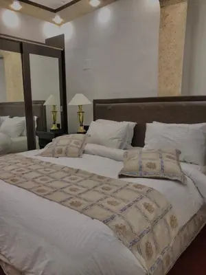 a bedroom with two beds with white sheets and pillows at ZRIZIRA INN in Wadi Musa