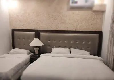 a bedroom with two beds and a lamp on a table at ZRIZIRA INN in Wadi Musa